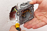 Electrician hand mounting a wall fixture