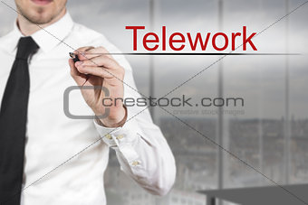 businessman writing telework in the air