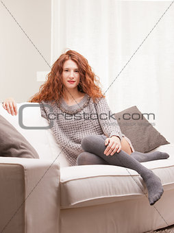 Red Headed very cute girl serious on her sofa