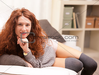 Red Headed very cute girl smiling on her sofa