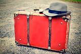 Old suitcase with watch and hat