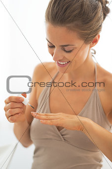 Young woman applying nail polish