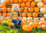Portrait of happy child sitting on pumpkin
