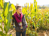 Happy young woman standing in cornfield and looking on copy spac