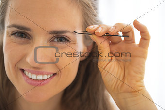 Portrait of happy young woman shaping eyebrows