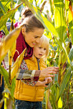 Portrait of happy mother and child exploring cornfield