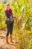 Full length portrait of happy young woman in cornfield