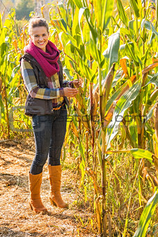 Full length portrait of happy young woman in cornfield