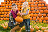 Portrait of happy mother and child choosing pumpkins