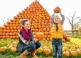 Portrait of happy mother and child pumpkin in front of pumpkin p