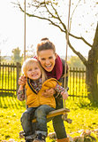 Portrait of smiling mother and child on swing