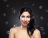 Young beautiful woman surrounded by bubbles