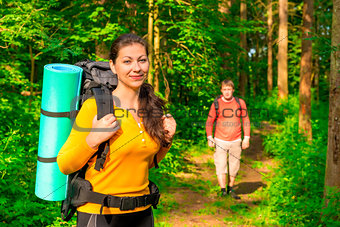 man and woman in the morning in the woods with backpacks