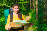 portrait of a tourist with a map in the forest