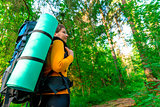 tourist with a backpack in the woods in search of the road