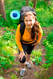 woman with a backpack up the hill in the woods