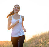 Young Beautiful Woman Running on the Mountain Trail in the Morning