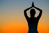 Young Beautiful Woman Practices Yoga on the Sunset