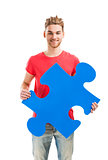 Young man holding a puzzle piece