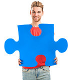 Young man holding a puzzle piece