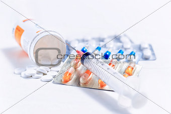 Syringe with glass vials and medications pills 