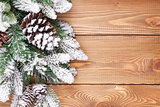 Christmas fir tree with snow on rustic wooden board