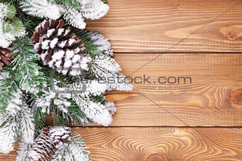 Christmas fir tree with snow on rustic wooden board