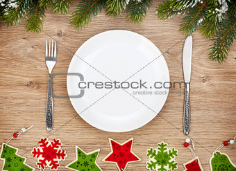 Empty plate with silverware, fir tree and christmas decor