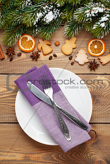 Empty plate with silverware over christmas wooden background