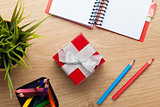 Red gift box and office supplies over office table