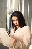 surprised businesswoman reading journal