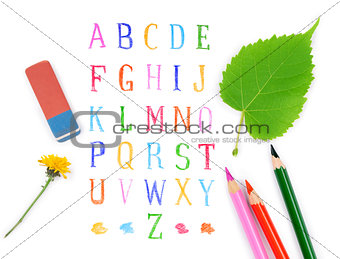 pencils and eraser on the background of the alphabet