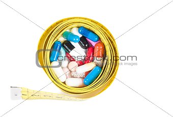 top of view of medical blue pills in front of measure tape, concept for diet