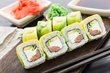 Sushi roll covered with avocado
