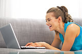Young woman using laptop in living room
