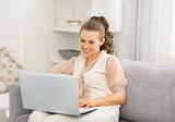 Young housewife using laptop in living room