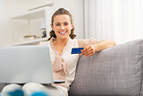 Happy young housewife with credit card making online shopping