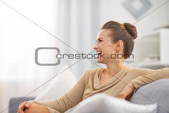 Smiling young housewife in living room