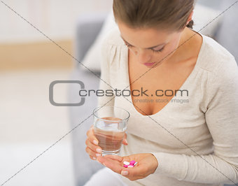 Closeup on young woman taking pills