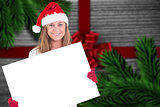 Composite image of festive blonde holding a poster