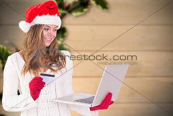Composite image of festive blonde shopping online with laptop