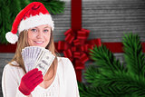 Composite image of festive blonde showing fan of dollars