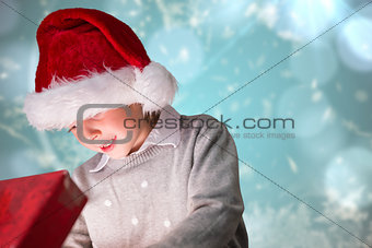 Composite image of festive boy opening gift