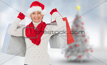 Composite image of festive woman holding shopping bags