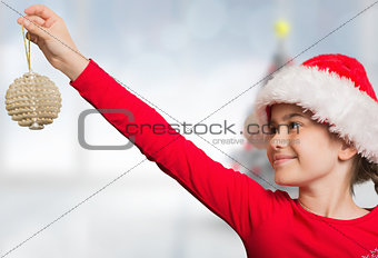 Composite image of festive girl hanging decoration