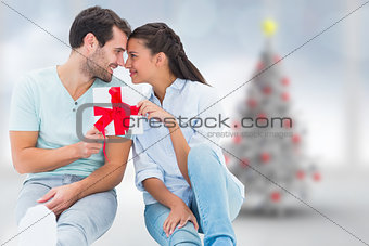 Composite image of young couple holding gift