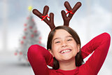 Composite image of festive little girl wearing antlers