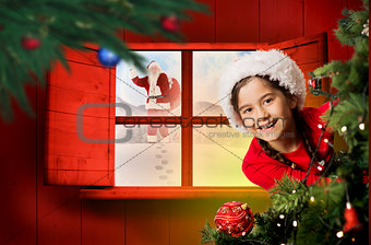 Composite image of festive girl looking from behind christmas tree