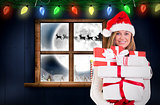 Composite image of festive blonde holding pile of gifts
