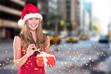 Composite image of festive blonde opening a gift